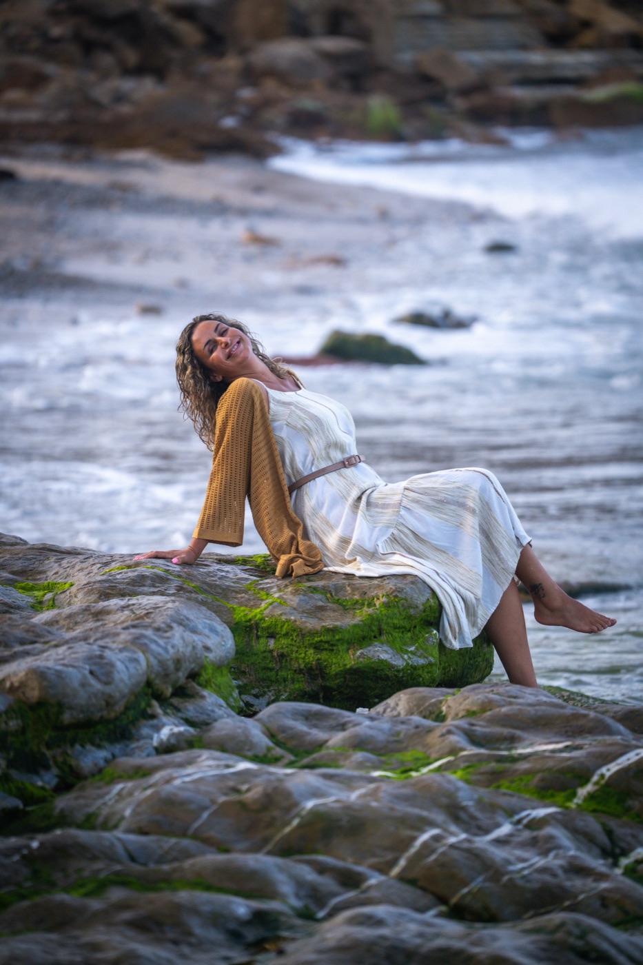 Filipa Lourenço sentada numa rocha, junto ao mar