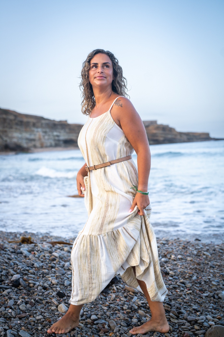 Filipa Lourenço a caminhar com confiança junto ao mar, olhar determinado