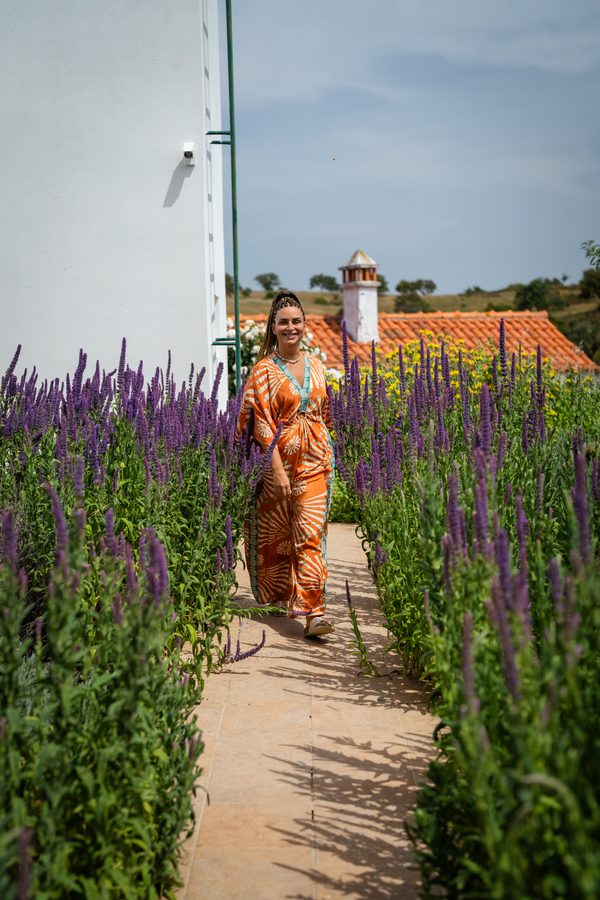 Filipa Lourenço num jardim com flores lilás